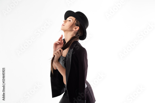 Stylish young woman in a black hat and jacket, close-up
