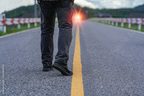 Wallpaper Mural The human leg walked along the path in the bright orange light of day. The man's feet moved slowly. Torontodigital.ca