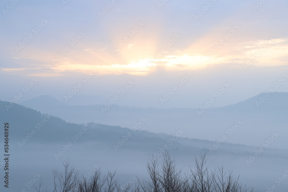 Sunrise in autumn with fog and clouds. Viewpoint in the Palatinate Forest. Morning mood in nature. Landscape shot on a mountain