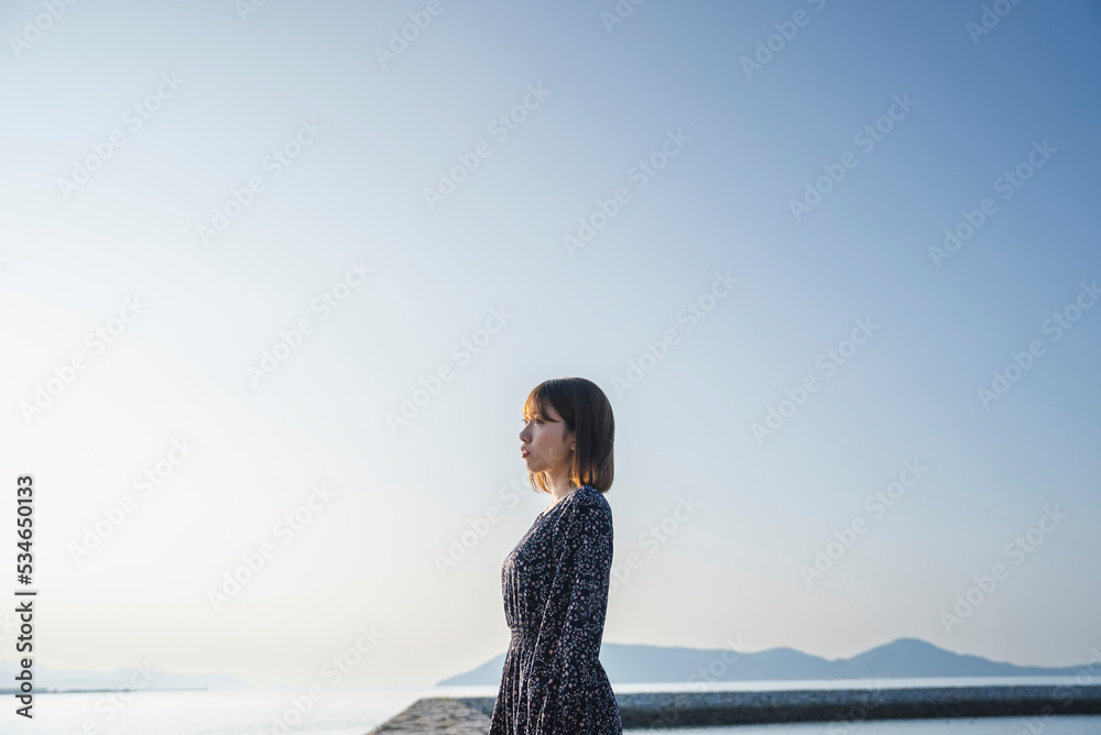 夕暮れの海にいる女性