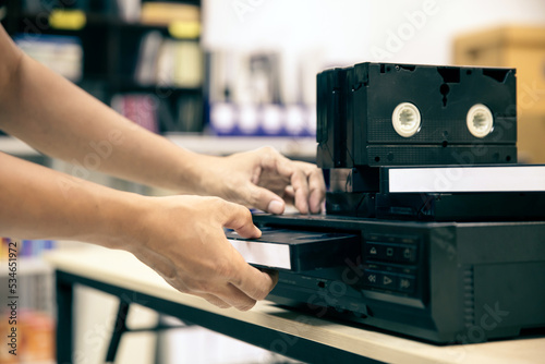 Close-up hand putt playback button on video record player concept of retro style or vintage electric and electronic appliances multimedia playback device old fashioned. © Eakrin