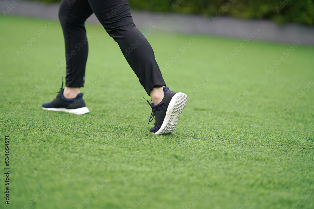 woman ,runner run with shoe on lawn grass woman ,runner run with shoe on lawn grass