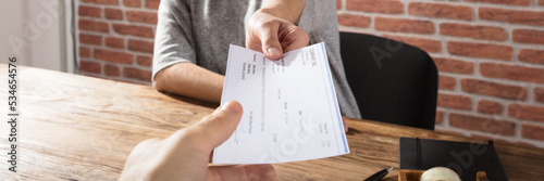 Woman Offering Company Cheque photo