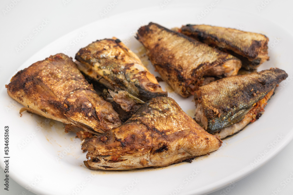 grilled milkfish or Ikan Bandeng Bakar on white plate isolated on white background