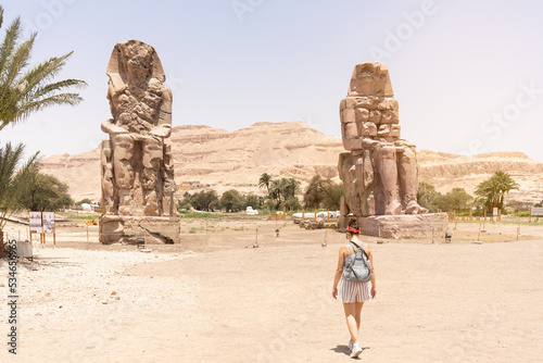 Woman walking towards an ancient egyptian statues photo