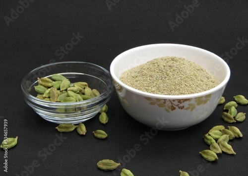 Green cardamom and cardamom powder in bowls 