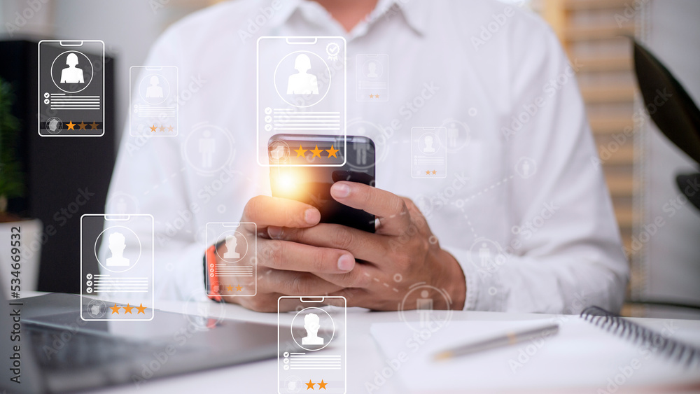 Online recruitment application specialist search service concept with virtual cards with rating and profile information on a smartphone in hand. Online recruitment application specialist search service concept with virtual cards with rating and profile information on a smartphone in hand.