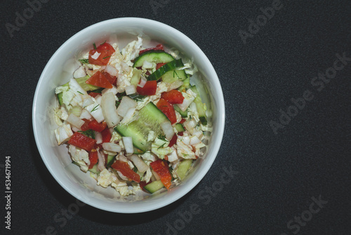 Vegetarian salad with tomato, lettuce, cucumber and onion. bowl with vegetables close up