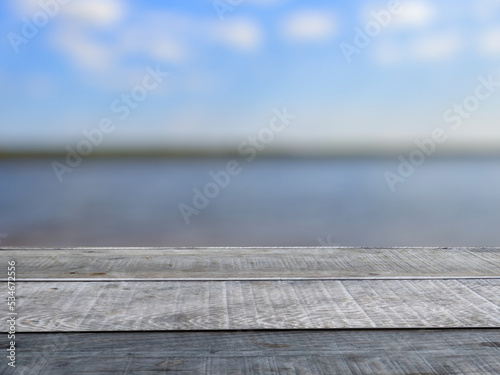 Old wooden table shelf, turquoise lake blur background.