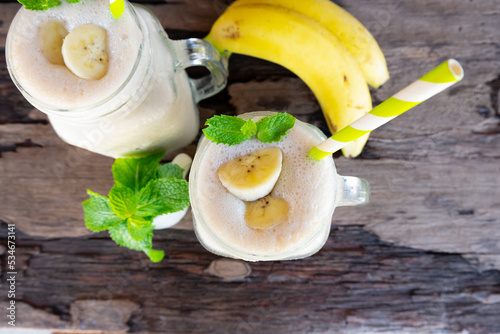 Banana fresh cocktail vanilla smoothies  fruit juice beverage healthy the taste yummy in glass drink episode good morning on wooden background from the top view.