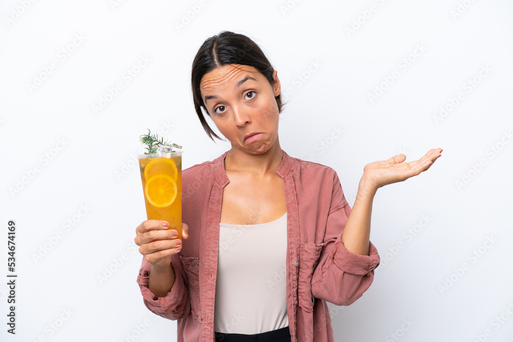 Young hispanic woman holding a cocktail isolated on white background having doubts while raising hands Young hispanic woman holding a cocktail isolated on white background having doubts while raising hands