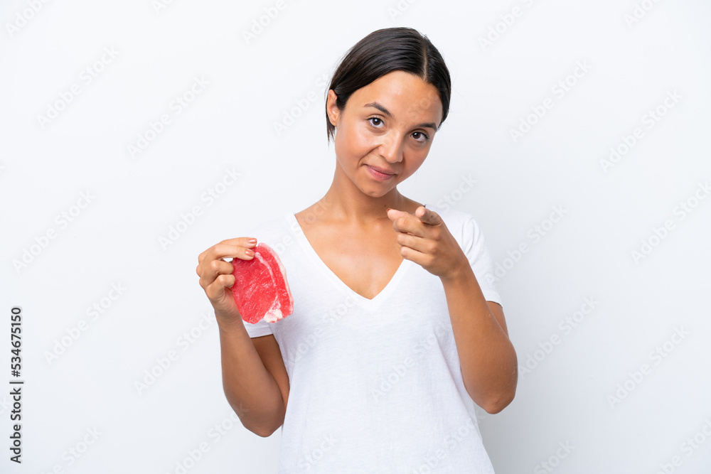 Young hispanic woman holding a piece of meat isolated on white background points finger at you with a confident expression Young hispanic woman holding a piece of meat isolated on white background points finger at you with a confident expression