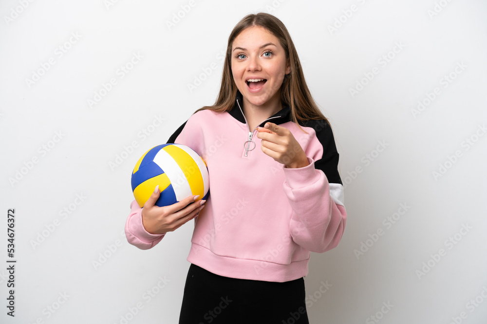 Young Lithuanian woman playing volleyball isolated on white background surprised and pointing front