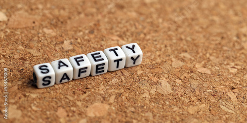 Closeup of word on plastic cube on wooden desk background concept - safety