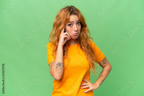 Young caucasian woman isolated on green screen chroma key background thinking an idea © luismolinero