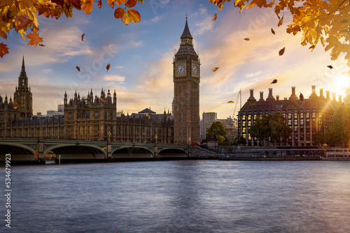 Beautiful autumn view of the Westminster Bridge and palace with Big Ben clocktower in London  golden branches and leaves and soft sunset light