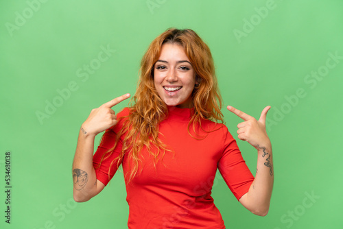 Young caucasian woman isolated on green screen chroma key background giving a thumbs up gesture