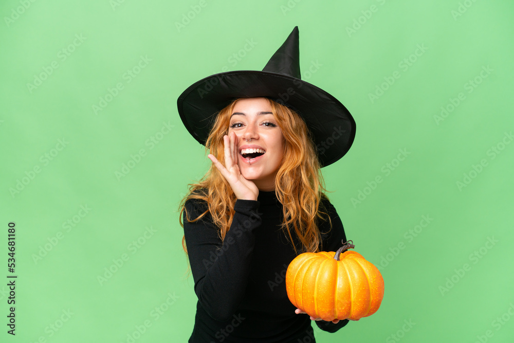 Young caucasian woman costume as witch holding a pumpkin isolated on green screen chroma key background shouting with mouth wide open Young caucasian woman costume as witch holding a pumpkin isolated on green screen chroma key background shouting with mouth wide open