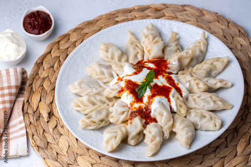 Traditional manti food on plate, top view. The concept of oriental cuisine. Uzbek food manty dumplings. (Turkish name; hinkel mantisi + cecen mantisi) photo