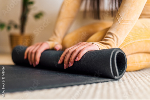 Closeup picture of yoga mat, being rolled after training.