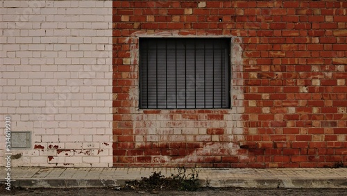 industrial area sidewalk with window and brick wall