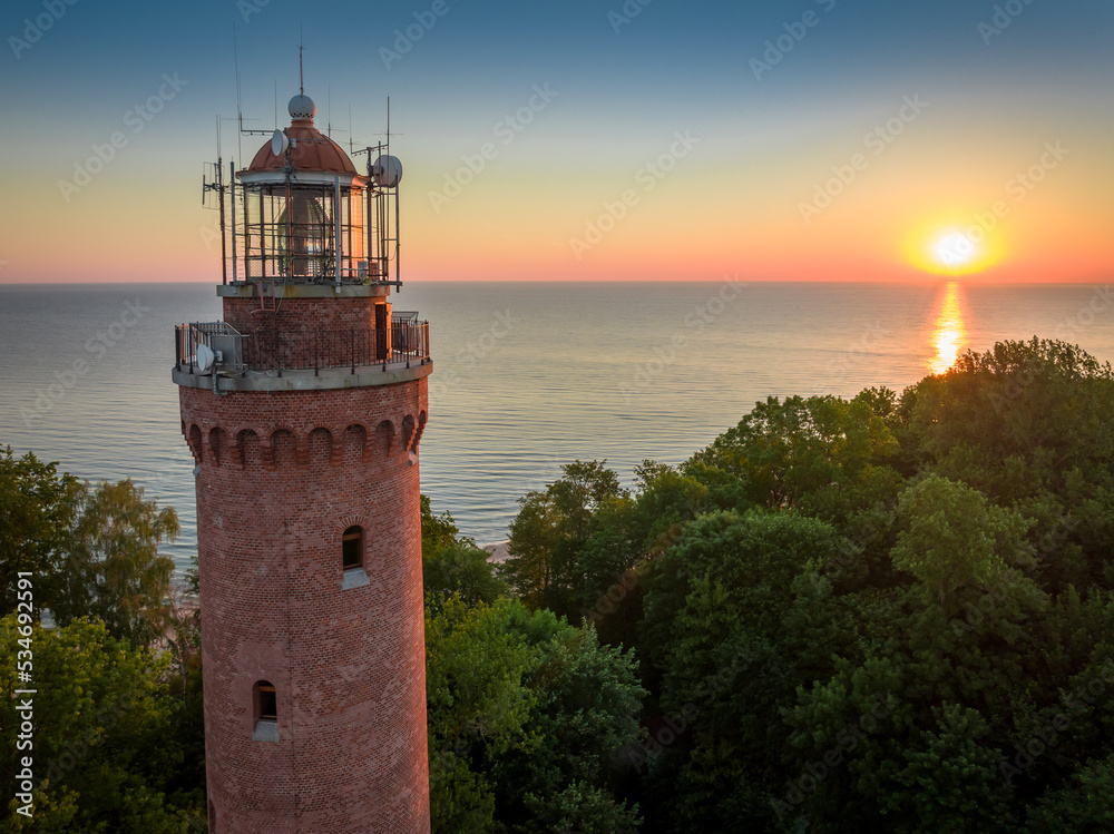 Lighthouse at sunrise by Baltic sea in Poland.