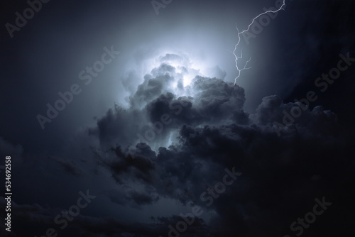 Lightning radiates through the clouds at night