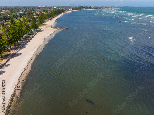 Aerial view of a sand bayside beach and coastline with a kite surfer photo