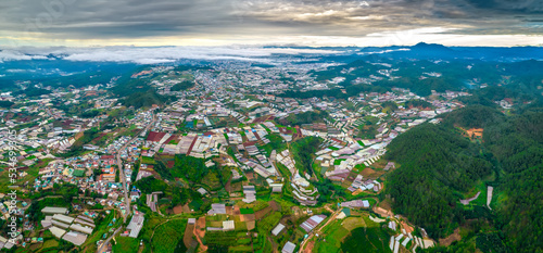 Suburb in the morning seen from above in the highlands of Da Lat, Vietnam. Where there are many greenhouses for organic farming and existing houses © huythoai