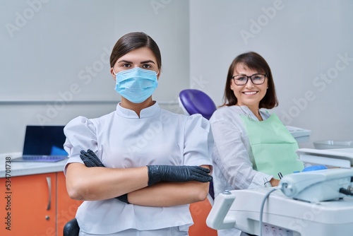 Portrait of female dentist with woman patient sitting in dental chair