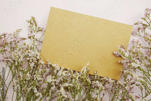 Empty card for text message and flower decoration on pink background