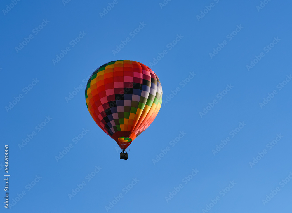 Color hot air balloon flying through the blue sky. Color hot air balloon flying through the blue sky.