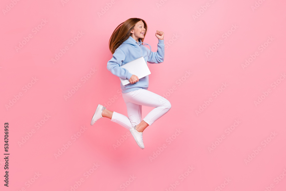 Full size profile portrait of carefree active person jump hurry run hold netbook isolated on pink color background
