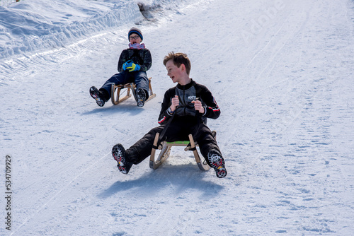 Fotografie kids riding sledges down the hill