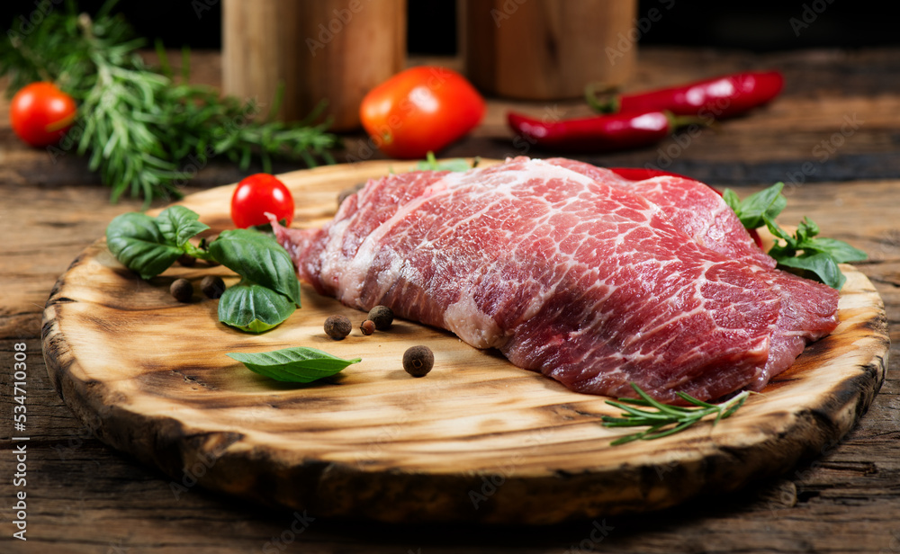 Raw meat on wooden table. Premium juicy Marble beef steak, Black Angus Steak Rib eye. Spices. On wooden plate.