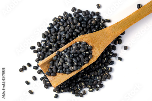 Black Lentils (Maa de Daal, Black matpe beans, Urad whole). Black Lentils with wooden spoon on white background