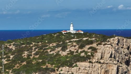 Lighthouse Atop A Steep Cliff Overlooking the Ocean in Ibiza photo