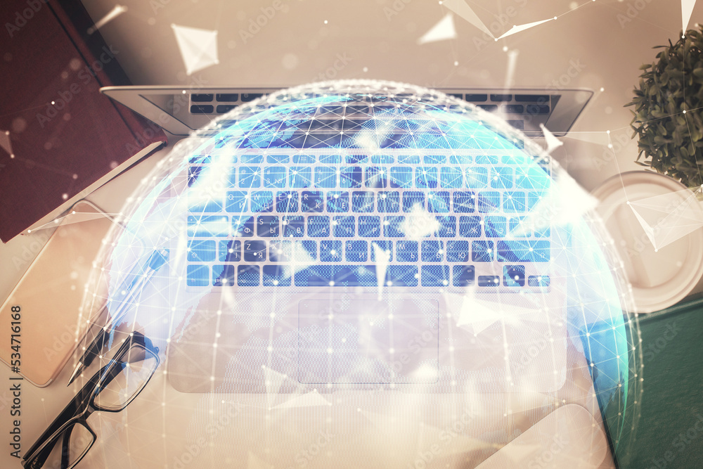 Business theme hologram drawings over computer on the desktop background. Top view. Multi exposure. Concept of international connections. Business theme hologram drawings over computer on the desktop background. Top view. Multi exposure. Concept of international connections.