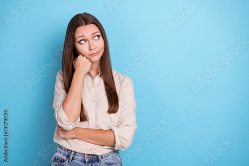 Photo of pretty upset lady problem difficult choice consider plan idea arm touch face look empty space isolated on blue color background © deagreez