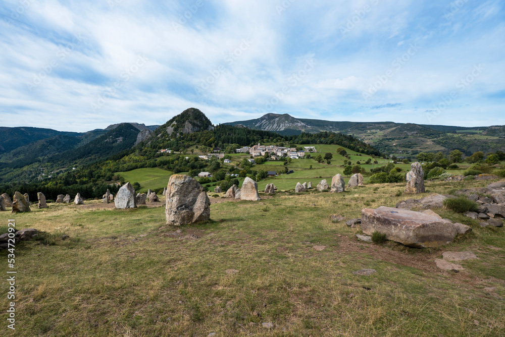 French Borée village with heavy menhir stones on the foreground and mountains on the background in Ardeche region.