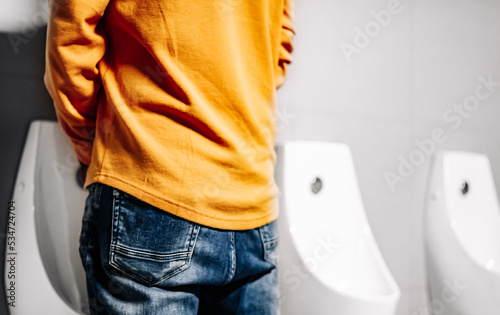 Obraz na plátně back Man peeing to toilet bowl in restroom