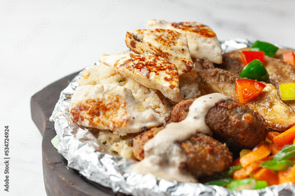 Close-up of veg vrat or fasting or upvas  sizzlers with paneer, potatoes carrots wooden plate, served burning  hot with fumes at table