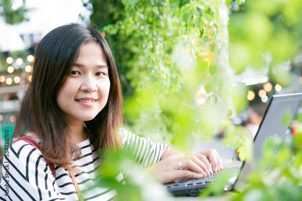 Business asian woman working with laptop in garden of cafe