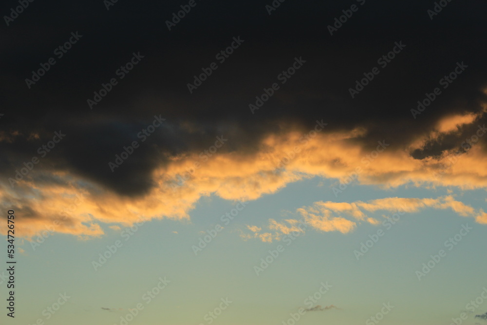 Dramatic cloudscape at sunset showing dark clouds and a clear blue sky. Concept for hard roads ahead or clouds with silver lining. Concept for changing mind, new horizon, new day, changing circumstane