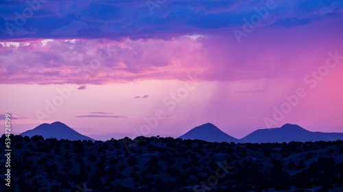 Usa, New Mexico, Lamy, Monsoon storm clouds forming over desert landscape at dusk photo