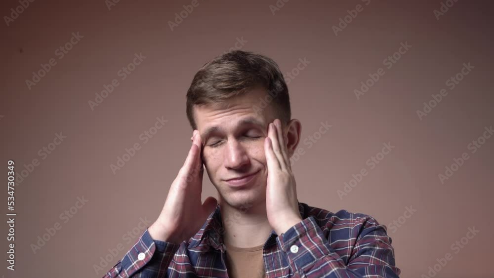 Stressed young man massages his head. migraine. caucasian appearance