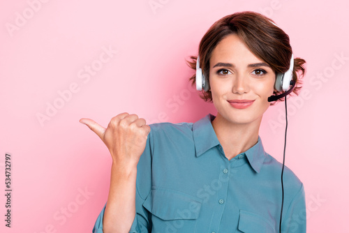 Photo portrait of pretty young lady point empty space call center assistant dressed trendy blue clothes isolated on pink color background