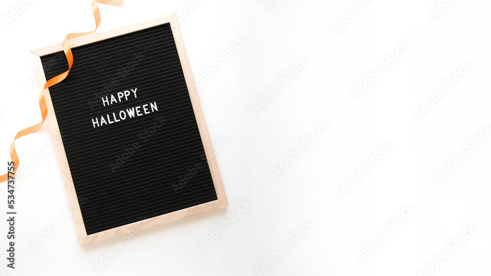 Lettering Happy Halloween in a wooden frame and an orange ribbon on a white background Lettering Happy Halloween in a wooden frame and an orange ribbon on a white background