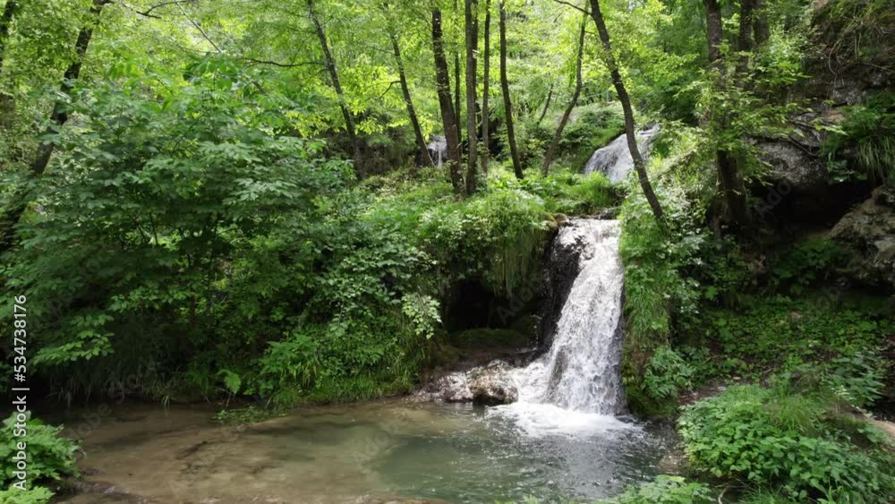 Aerial view of a mountain stream with waterfalls and a picturesque environment of plants and rocks around it covered with moss Aerial view of a mountain stream with waterfalls and a picturesque environment of plants and rocks around it covered with moss