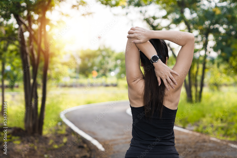 Asian woman in sports outfits doing stretching before workout outdoors in the park in the morning Asian woman in sports outfits doing stretching before workout outdoors in the park in the morning